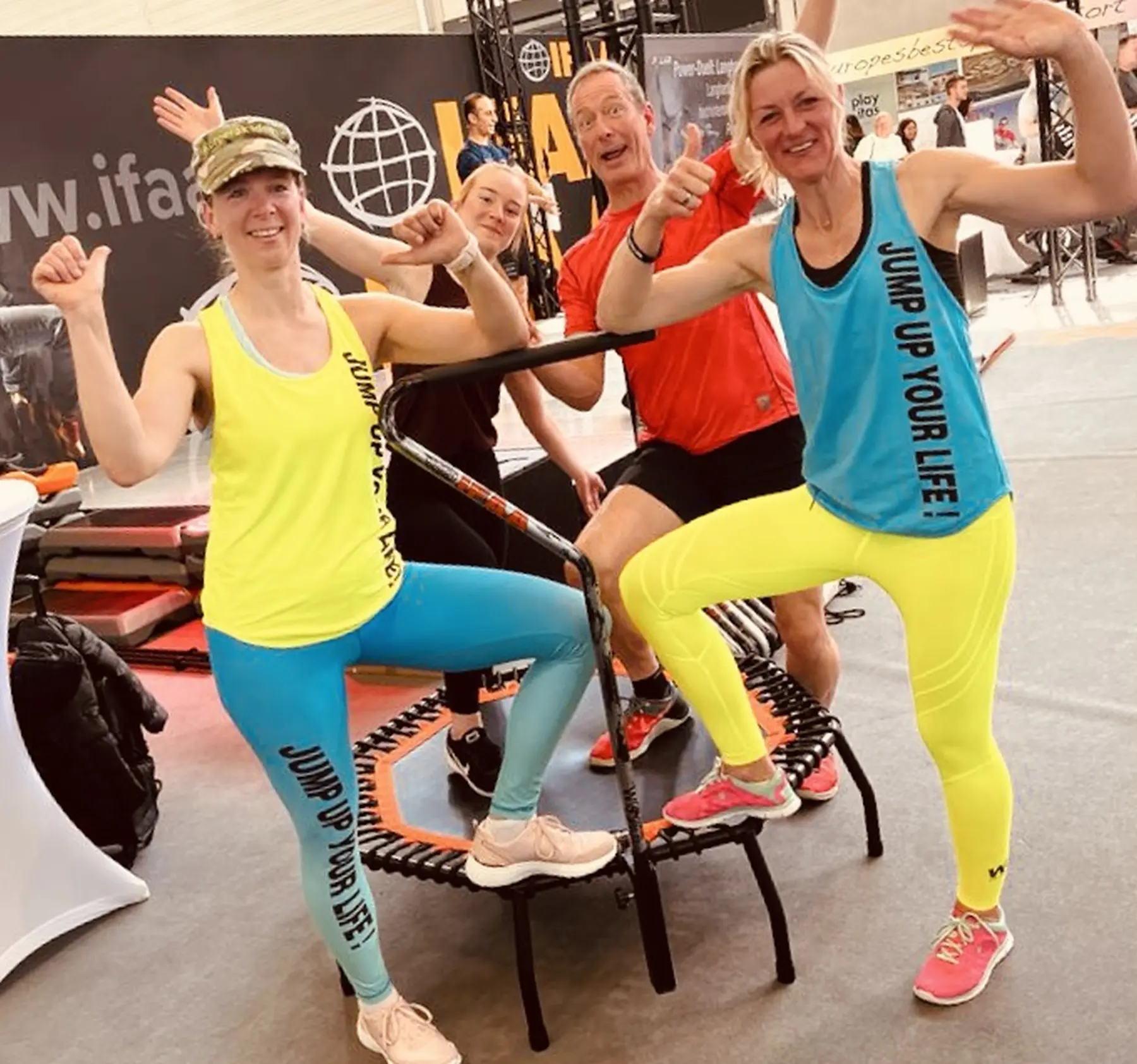 Veranstaltung der Körperakademie, Fitnessteam posiert für ein Foto, stehend auf einem Trampolin