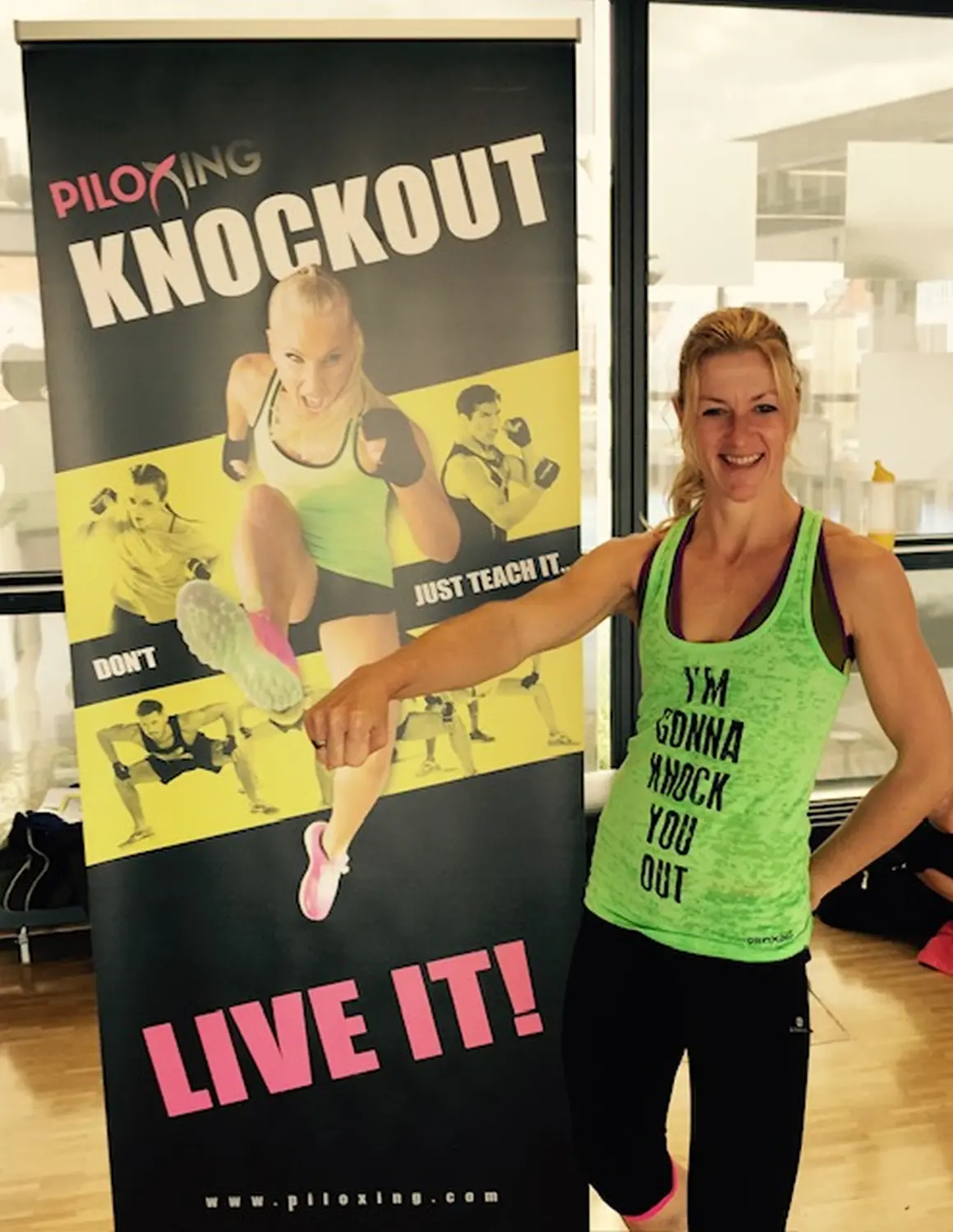 Körper akademie Piloxing Ausbildung, Eine Frau steht vor einem Plakat